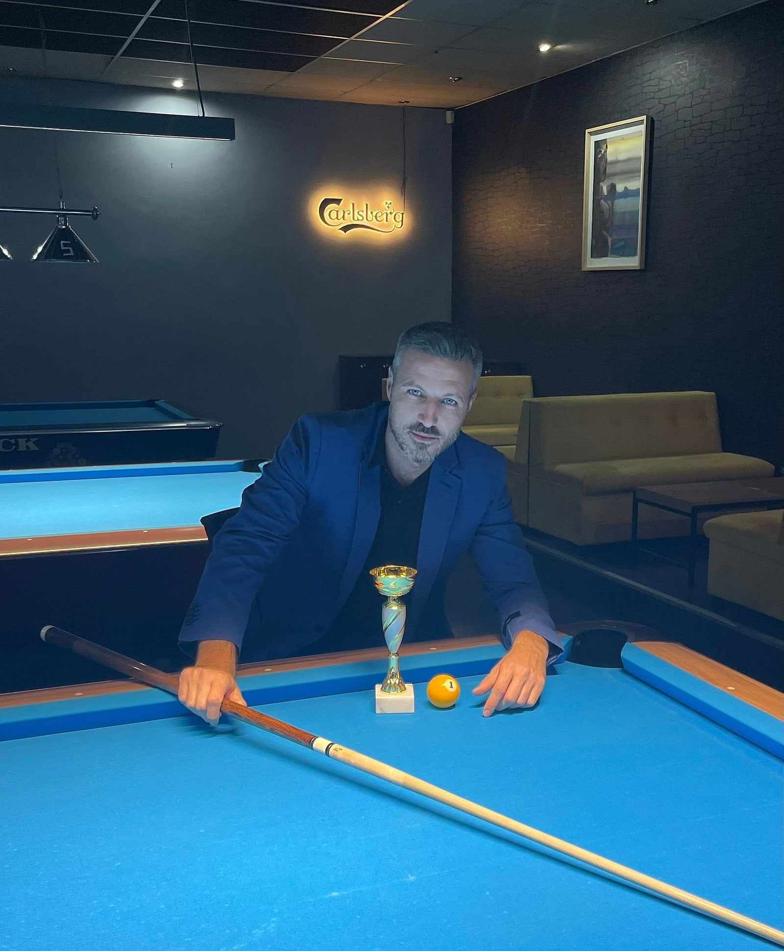 Boyan Sopadzhiev with a trophy and cue at the table