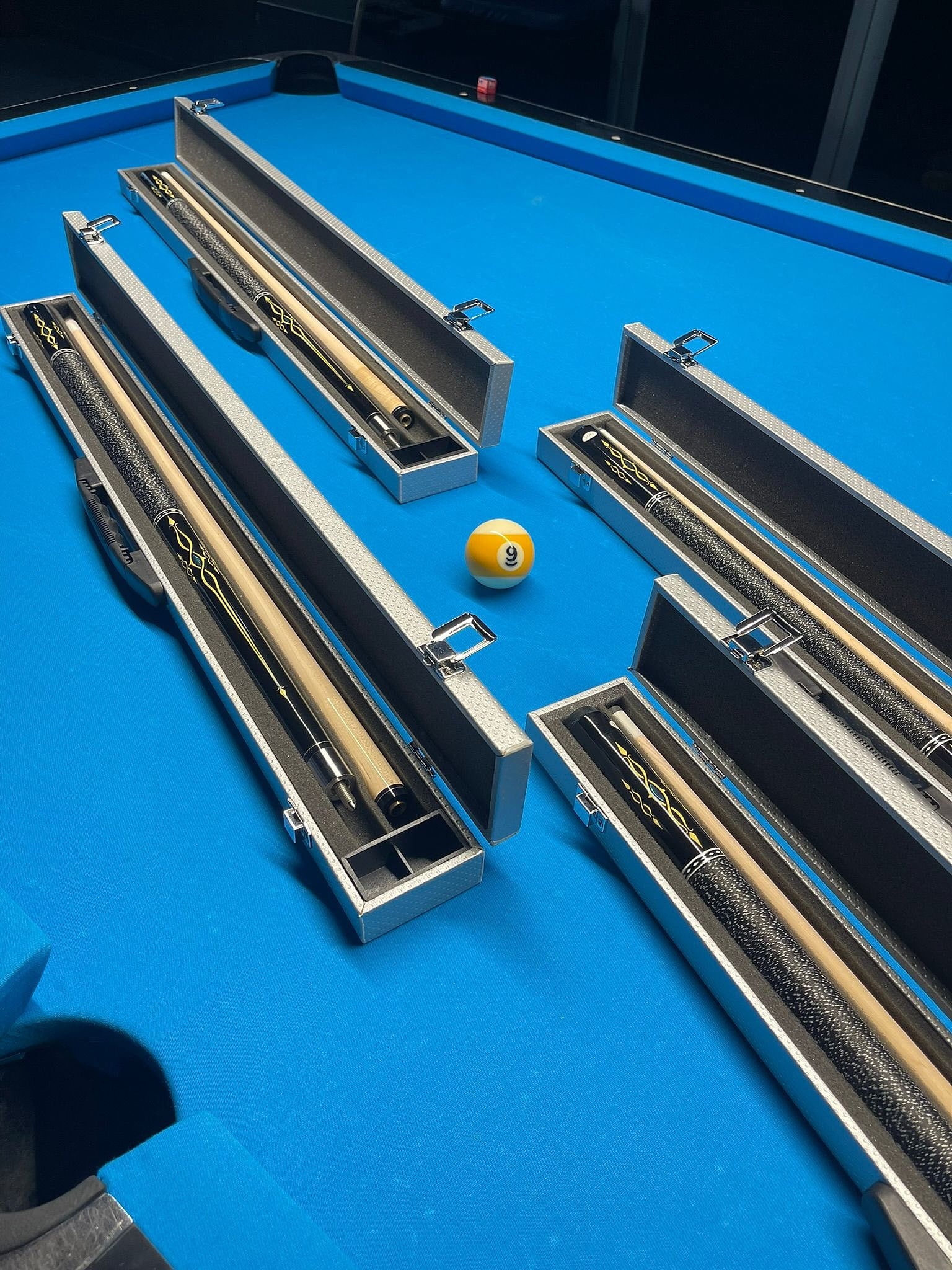 Cue cases on the blue cloth