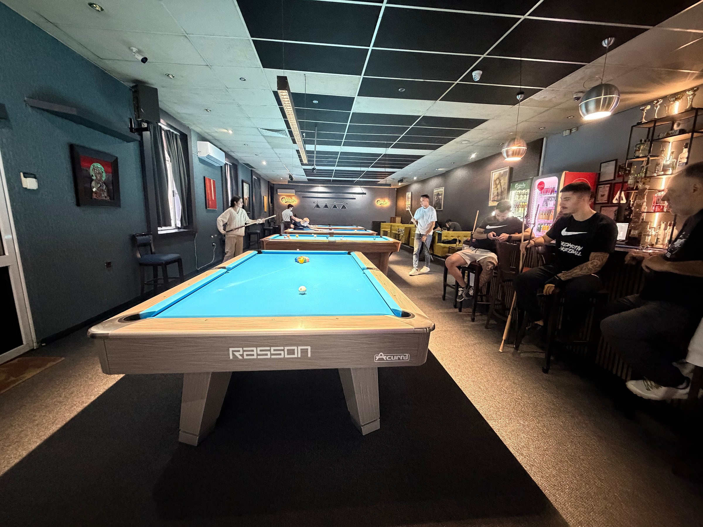 The room: a row of tables, players at the back